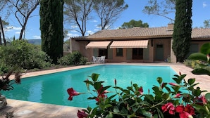 A swimming pool with a tiled deck, surrounded by greenery and trees. - Villa with a 12.5 metre swimming-pool, not far from the sea (Puget-sur-Argens)