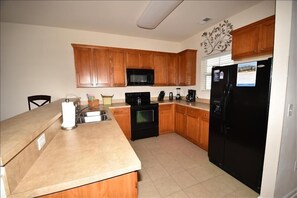 Fully equipped kitchen with microwave, stove, sink, and appliances.