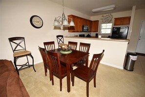 Cozy living space with a dining area and kitchenette, featuring a comfortable couch, dining table, and small side table.