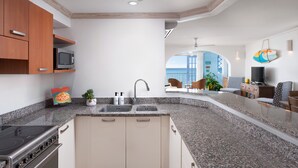 Eine moderne Küche mit Granit Arbeitsplatten, einem eingebauten Herd und einem Spülbecken. Darüber befindet sich eine Mikrowelle und auf der Arbeitsfläche ein kleiner Topfpflanze.