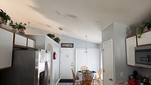 Une cuisine moderne avec un coin repas, un plancher en bois et des appareils électroménagers intégrés.