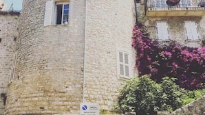 A stone tower with a round shape, a window, and a balcony with metal railings. - Stunning, Upmarket and Newly furnished Apartment nearby all Major Attractions (Antibes)