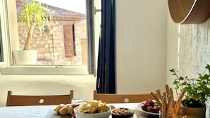 A dining table with a variety of foods, a candle, and a view of a building through a window. - Stunning, Upmarket and Newly furnished Apartment nearby all Major Attractions (Antibes)