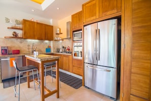 Enjoy cooking in this kitchen with a bar area, oven, and various appliances.