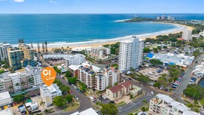 Un paysage urbain côtier avec de hauts immeubles, une plage et un parking.
