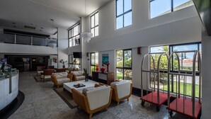 A spacious living area with a high ceiling, large windows, and a modern design. - Flat with spectacular view of PONTA NEGRA BEACH, 55 MB Wi-Fi, garage (Natal)