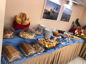 A buffet table with various food items and a tropical-themed decoration. - 2-bedroom apartment with views of Morro do Careca, 250m from the sea, garage, Wi-Fi. (Natal)