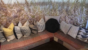 A sectional sofa with patterned cushions and a textured throw blanket.