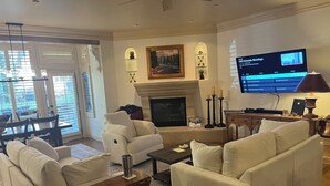 A living room with a fireplace, a television, and a dining area with a table and chairs. - True Ski in Ski Out Located In Arrowhead village. 3 Bed / 3 Bath Unit (Edwards)