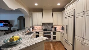A kitchen with white cabinets, a granite countertop, a stainless steel refrigerator, and a wooden floor. - True Ski in Ski Out Located In Arrowhead village. 3 Bed / 3 Bath Unit (Edwards)
