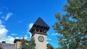 A courtyard with a stone fire pit, benches, and a clock tower. - True Ski in Ski Out Located In Arrowhead village. 3 Bed / 3 Bath Unit (Edwards)