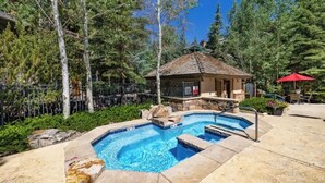 A backyard with a swimming pool, a small gazebo, and a red umbrella. - True Ski in Ski Out Located In Arrowhead village. 3 Bed / 3 Bath Unit (Edwards)