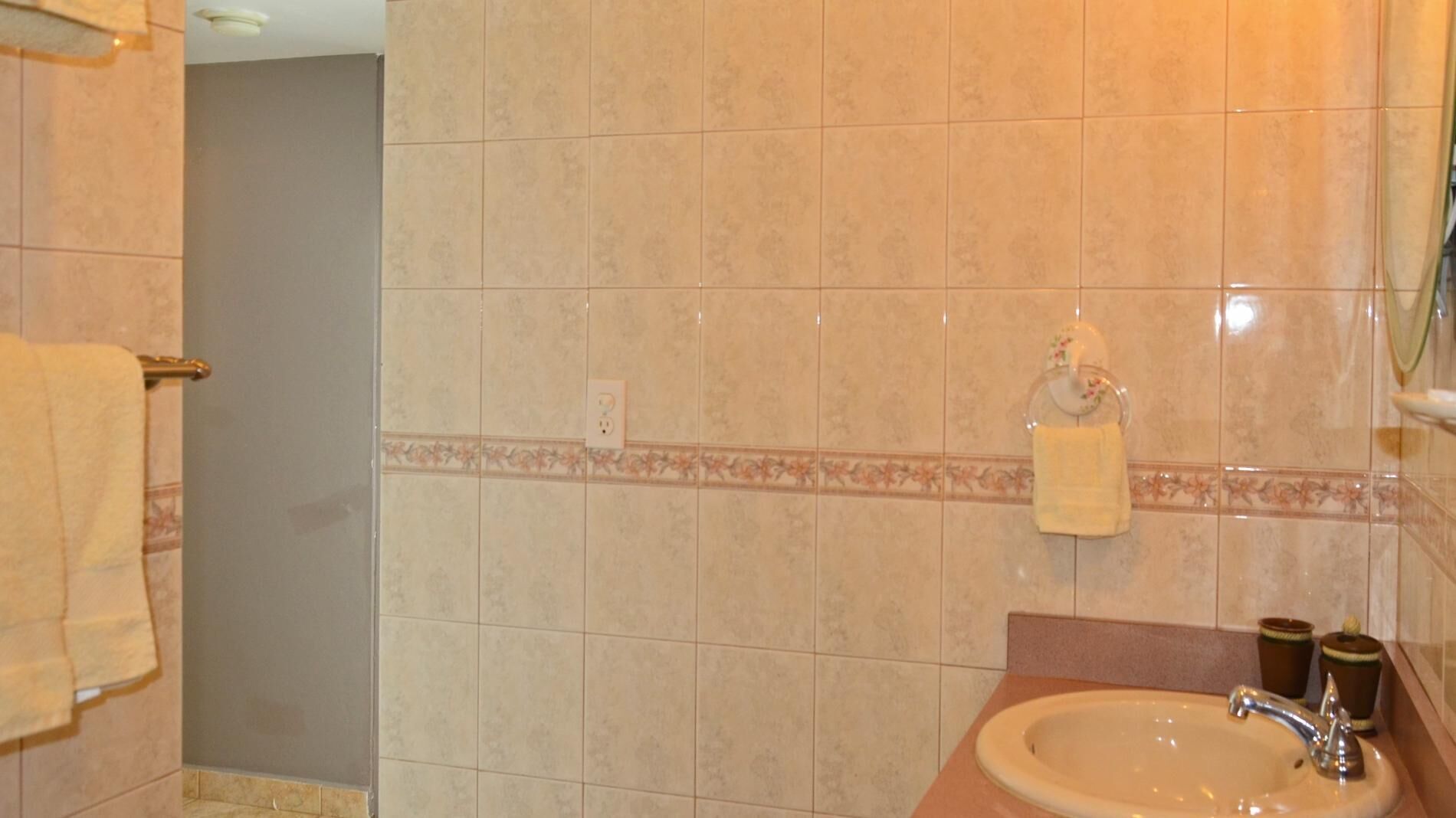 A bathroom with a sink, mirror, and towel rack.