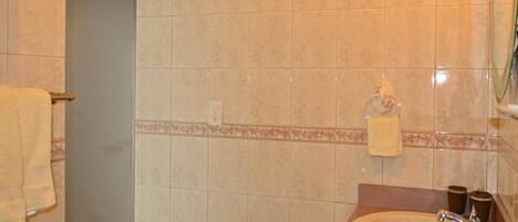 A bathroom with a sink, mirror, and towel rack.