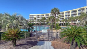 A hotel with a pool area, palm trees, and a sign indicating no trespassing. - Gulf Front**Free Beach Service & Wi-Fi**  (Miramar Beach)
