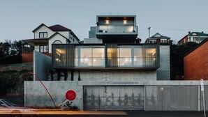 A modern building with a large garage door, a balcony, and a sign indicating a 25-minute parking duration.