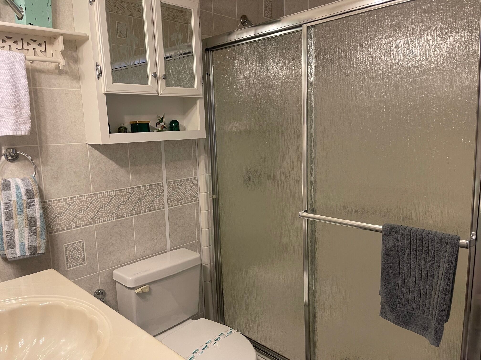 A bathroom with a shower, toilet, and sink.