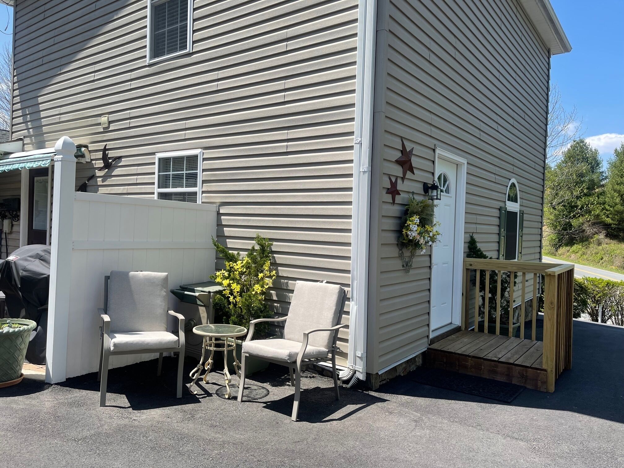 A house with a covered patio area featuring outdoor furniture and a small table.