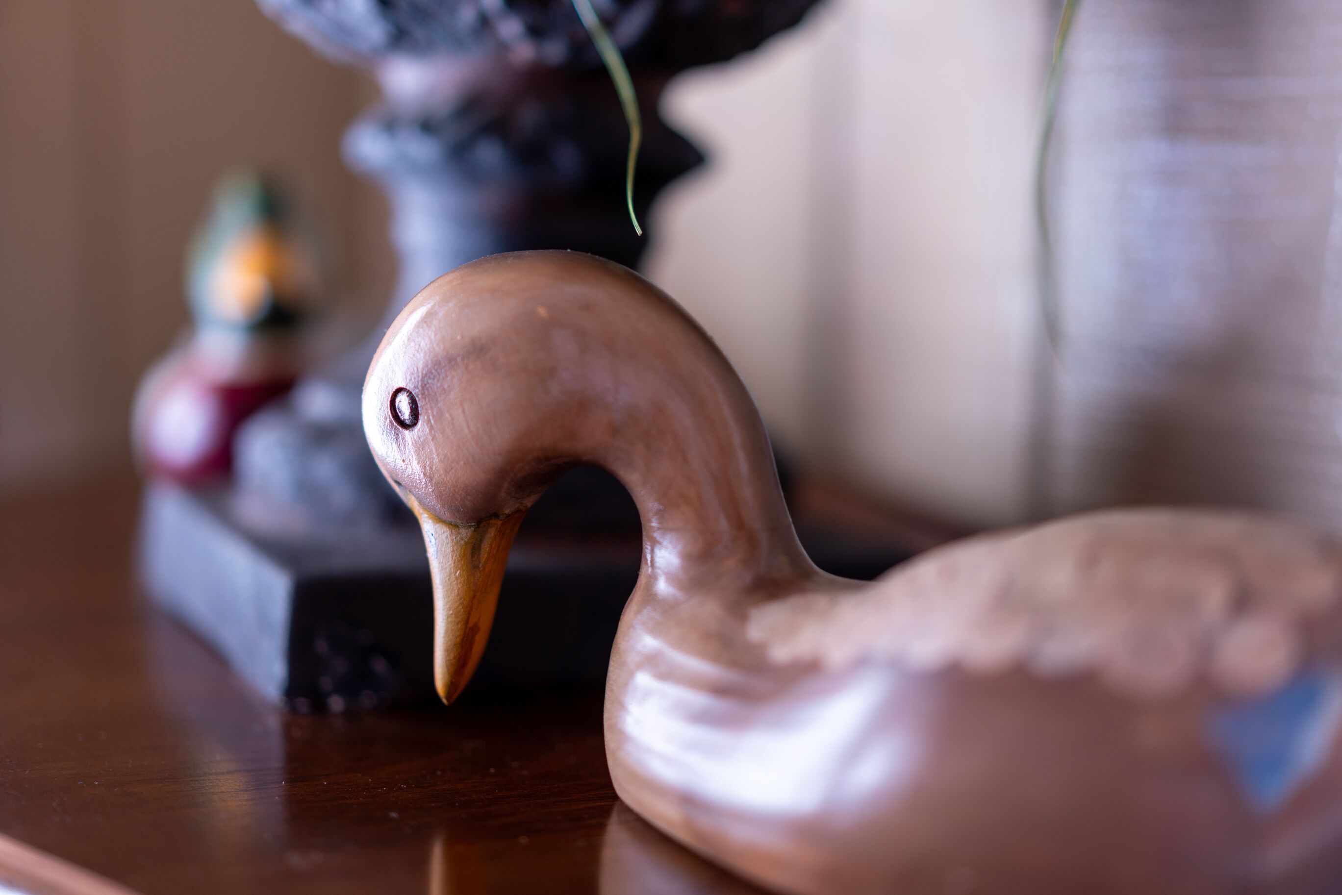 A wooden swan sculpture on a table.