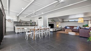 A modern interior with a dining area, kitchen, and living space. - Bronze @ Lennox Head (LENNOX HEAD)