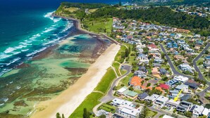 An aerial view of a coastal residential area with houses, a beach, and a rocky shoreline. - Bronze @ Lennox Head (LENNOX HEAD)