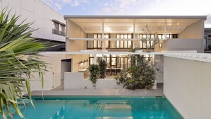 A modern two-story house with a swimming pool, outdoor seating area, and a covered patio. - Bronze @ Lennox Head (LENNOX HEAD)