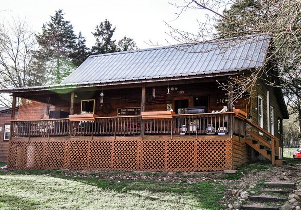 A wooden cabin with a porch, a metal roof, and a sign indicating nearby locations.
