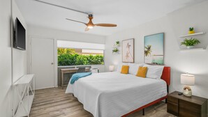 A modern bedroom with a bed, bedside table, and a ceiling fan.