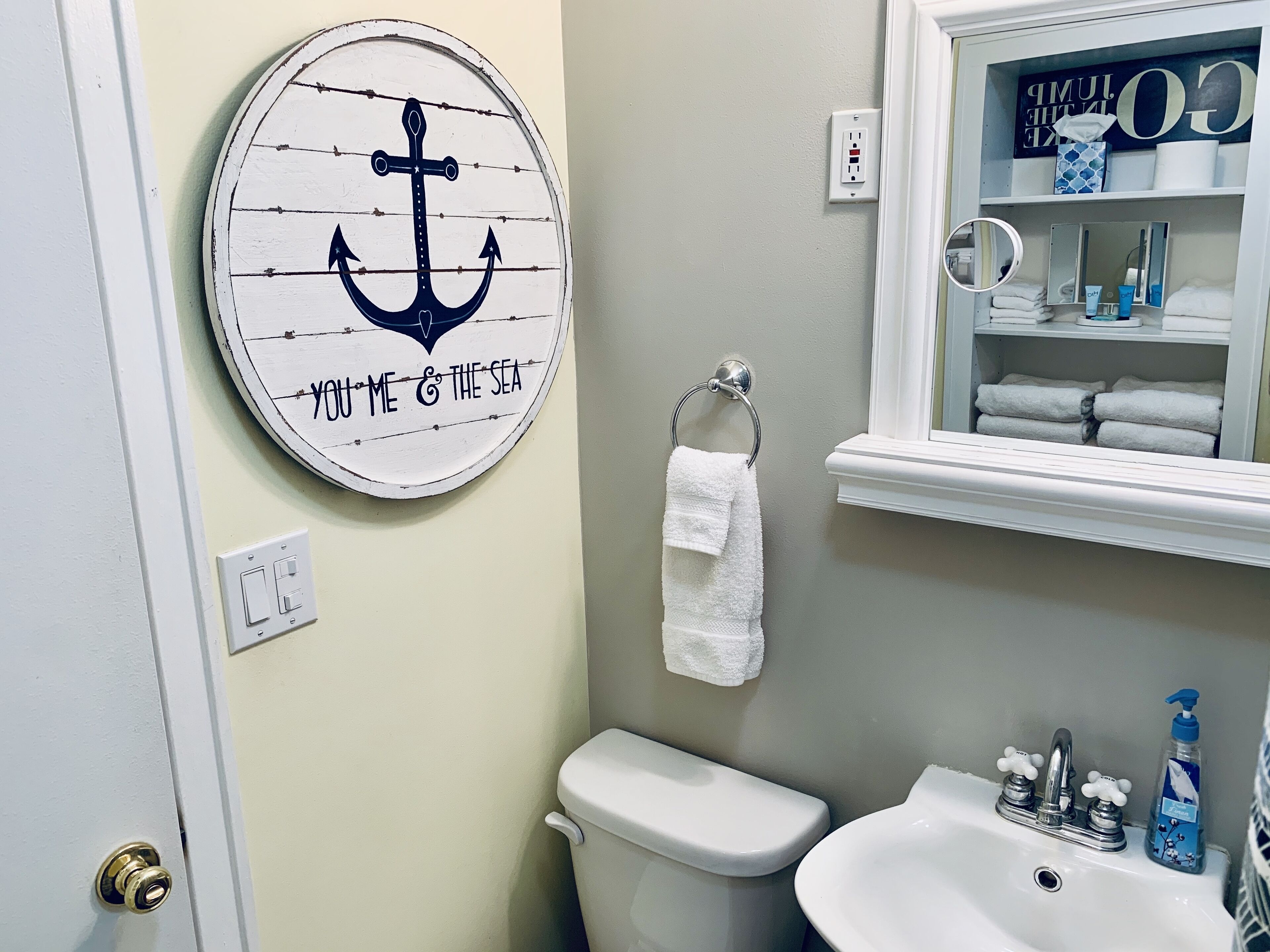 Un baño con inodoro, lavamanos y toallero.