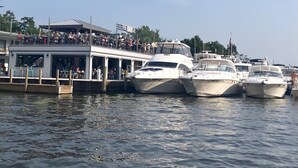 Een restaurant aan het water met een overdekt terras en diverse boten in de buurt afgemeerd.