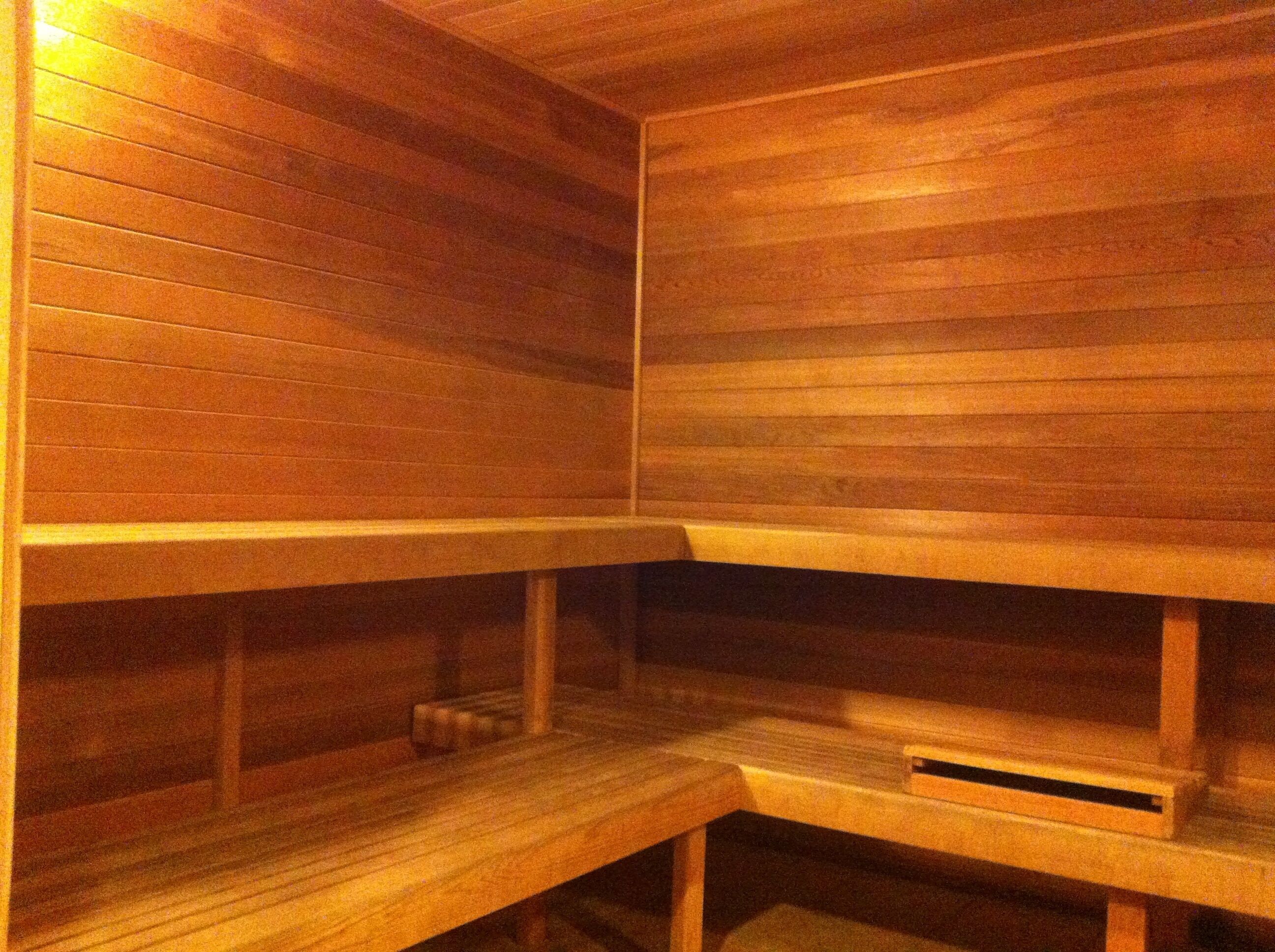 A wooden sauna with benches and shelves.