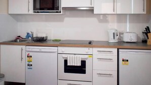 A kitchen with white cabinets, a microwave, a toaster, and a dishwasher. - Toogooloowa on Davey 5 (Hobart)