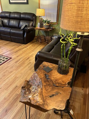 Relax in this stylish living room with a black leather sofa, wooden coffee table, and elegant lamp.