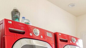 Una secadora roja a vapor con un panel de control y un depósito de agua en la parte superior.