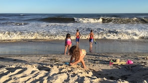 Children play near the water's edge on this sandy beach.