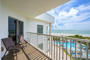 Un balcón con vista a la playa y al área de la piscina.