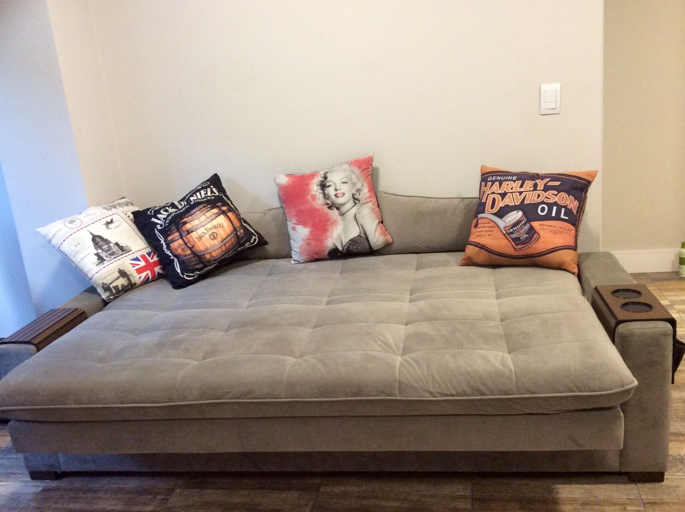 Ein graues Sofa mit drei dekorativen Kissen in verschiedenen Designs.