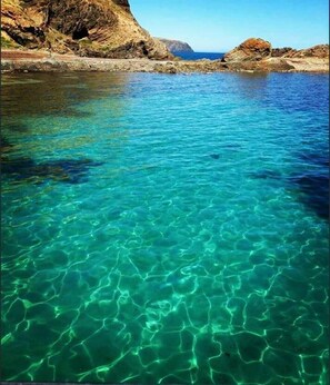 A clear blue sea with rocky cliffs in the background. - Second Valley Holiday House Close to Beach (Second Valley)