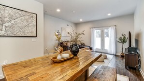 A modern living room with a wooden coffee table, a map artwork, and a sofa.