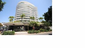 Experience the unique, curved design of this hotel, featuring layered balconies and a covered entrance, set amidst beautifully maintained gardens.