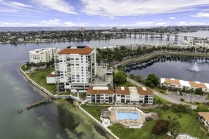 A high-rise hotel with a swimming pool, waterfront views, and a bridge in the background.