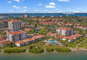A resort with multiple buildings, a swimming pool, and a view of the ocean.