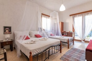Un dormitorio con dos camas, cada una con dosel, una mesita de noche, una lámpara y un cuadro enmarcado en la pared.