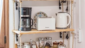 Une étagère en bois avec des appareils de cuisine et des ustensiles.