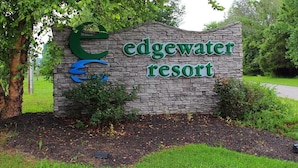 A stone sign with the text "Edgewater Resort" and a stylized 'E' logo.
