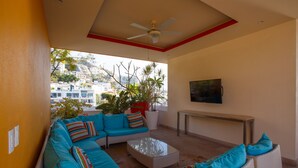 A modern living room with a sofa set, a coffee table, and a TV mounted on the wall. - Charming Condo in V177! 1BD Condo for rent in Old Town, Puerto vallarta (Puerto Vallarta)