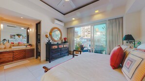 A hotel room with a large bed, a vanity with a mirror, a dresser, and a balcony with a view of the city. - Charming Condo in V177! 1BD Condo for rent in Old Town, Puerto vallarta (Puerto Vallarta)