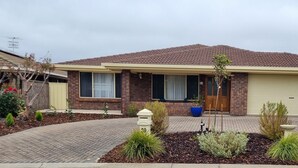 A two-story house with a tiled roof, a front garage door, and a brick facade. - Seas the Day - Lakefront getaway by the beach (Encounter Bay)