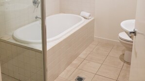 A bathroom with a glass shower enclosure, a bathtub, and a toilet. - Le Jarden Vue Du Port - Airlie  Beach (Airlie Beach)