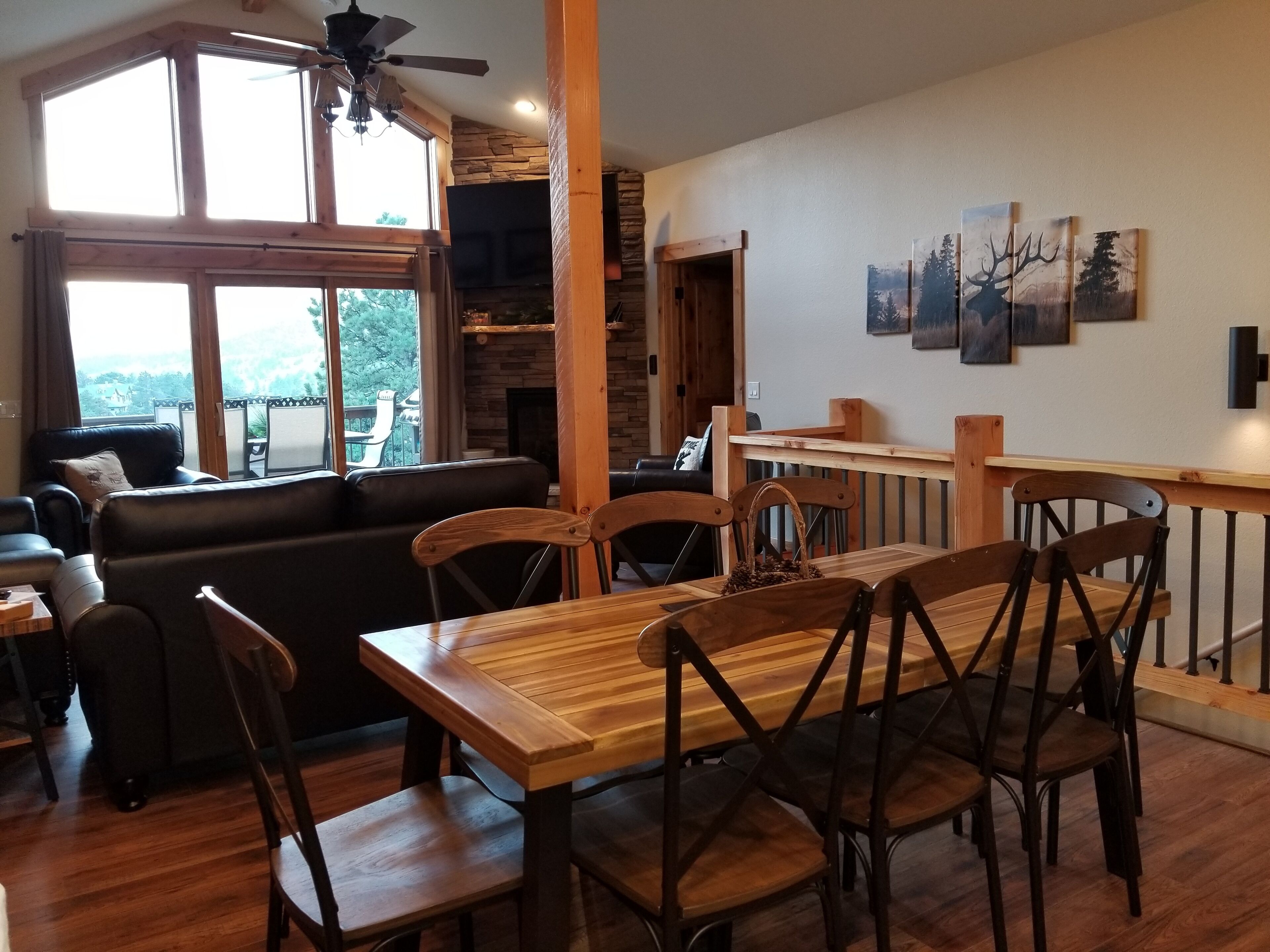 Un espace repas avec des meubles en bois, une cheminée et des œuvres d’art accrochées au mur.
